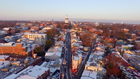 Aerial-shot-of-Maryland-state-capital-building-and-snowy-downtown-Annapolis-main-Street-during-purple-sunrise-light