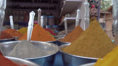 Pull-back-close-up-through-colourful-piles-of-mixed-herbs---spices-in-outdoor-store-market-scene