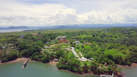Tiro-Horizontal-De-Drones-De-Una-Hermosa-Ubicación-De-Vacaciones-Junto-Al-Mar-En-Un-Bosque-Con-Fondo-De-Montaña-Y-Cielo-Nublado,-Boca,-Chica,-Panamá