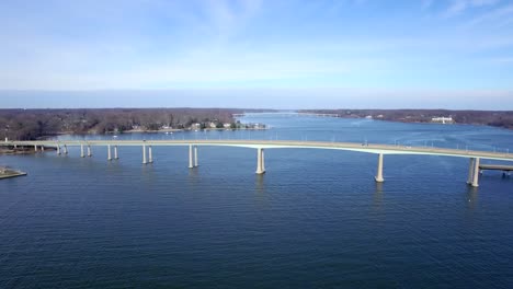 Heading-down-river-moving-away-from-two-bridges-on-a-clear-blue-winters-day-above-the-Chesapeake-Bay
