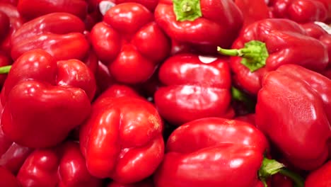 Colorful-red-bell-pepper-in-a-pile,-SLOWMO-Close-Up-Pan