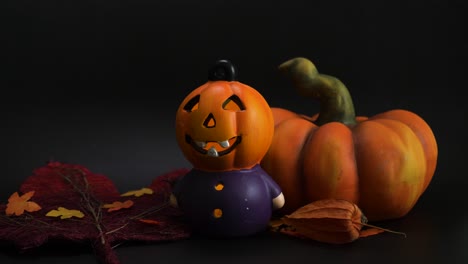 Halloween-Herbstdekoration-Mit-Beleuchtetem-Party-Kürbiskopf,-Anderen-Künstlichen-Kürbissen-Und-Blättern-In-Orangefarbenen-Farben-Auf-Schwarzem-Hintergrund