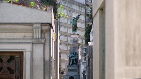 Angel-and-Three-men-holding-flag-mausoleum-statue-in-La-Recoleta-Cementery-at-daytime-long-shot