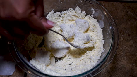 Overhead-view-of-breading-cauliflower-in-bowl-of-flour,-Slow-Motion