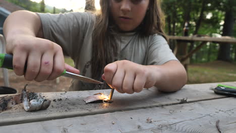 Kid-producing-sparks-from-a-magnesium-fire-starter-with-a-knife