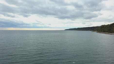 Aerial-view-of-Lake-Ontario-and-the-Scarborough-Bluffs,-with-a-smooth-drone-forward-movement