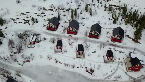 Traditional-red-Rorbu-cabin-with-coastline-at-evening-in-winter,-village-in-Lofoten-Islands-archipelago,-Norway