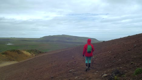 dramatic-iceland-landscape,-person-hiking-on-trail,-krysuvik-seltun-area,-camera-following-movmement,-camera-tracking---dolly-in-on-a-steadicam-gimbal-stabiliser