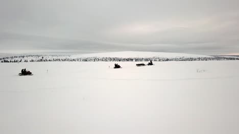 Drone-view-of-snowscootering-in-Saariselka,-Lapland,-Finland