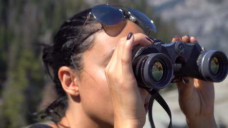 4K-Young-Pretty-Girl-Looking-at-Half-Dome-Through-Binoculars-on-Glacier-Point-in-Yosemite-National-Park,-Caliofrnia