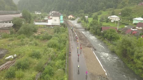 Aerial-view-of-Tura-Cu-Copaci-cycling-race-in-Colibita,-Romania-with-drone-flying-forward