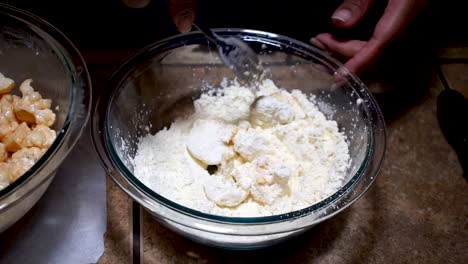 Stirring-cauliflower-in-flour-mix-with-fork-while-breading,-SLOW-MOTION