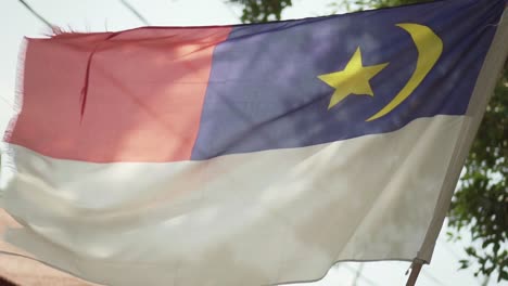 A-Waving-Melaka-Flag-With-Tree-And-Blue-Sky-Background