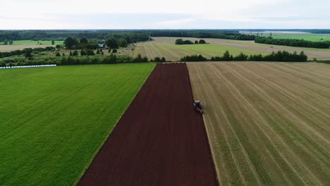 Agroculture-field-ploughing-with-four-furrow-reversible-plough-aerial-wide-view