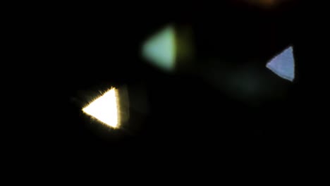Abstract-PINHOLE-camera-triangle-bokeh-follow-car-head-and-tail-lights-at-night-in-slow-motion-colorful-black