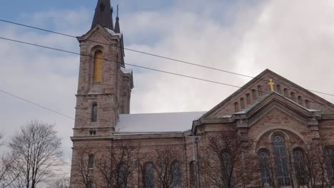 La-Iglesia-De-San-Carlo-En-Tallin-Se-Eleva-Con-Un-Espectacular-Cielo-Blanco-Y-Azul,-Con-Algo-De-Nieve-En-El-Techo