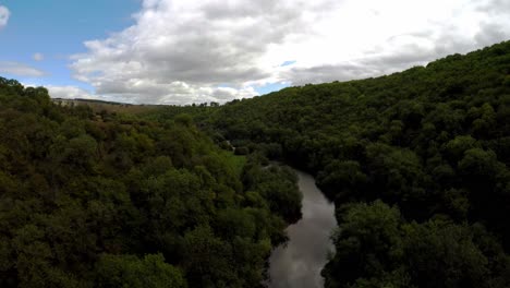 Luftaufnahme-Eines-Flusses,-Der-Durch-Einen-Wald-Im-Peak-District-Fließt,-Häufig-Von-Radfahrern-Und-Wanderern-Genutzt,-Beliebt-Bei-Touristen-Und-Urlaubern,-Ländliches-England,-Vereinigtes-Königreich