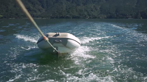 Bote-Inflable-Remolcado-Con-Una-Cuerda-Detrás-Del-Barco-En-El-Océano-De-Nueva-Zelanda