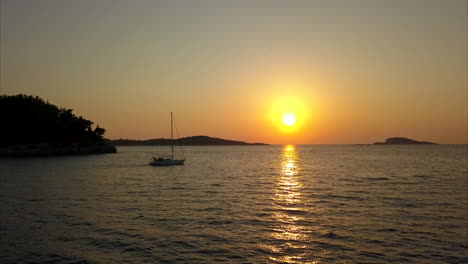 Sonnenuntergang-In-Kroatien-Mit-Vorbeisegelndem-Boot