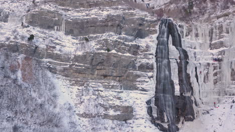 Eisbergsteiger-Erklimmen-Einen-Gefrorenen-Wasserfall-–-Langsames-Zoomen-Und-Rutschen