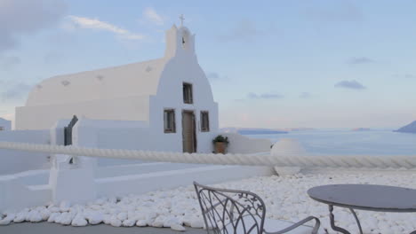 Tracking-in-shot-of-a-small-Greek-chapel-overlooking-the-caldera-with-an-amazing-sea-view
