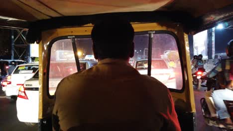 Wide-angle-view-from-inside-of-an-autorickshaw-driving-through-traffic-during-night-time