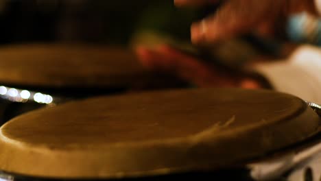Close-up-shot-of-Caribbean-male-playing-the-drums-at-a-concert-at-night