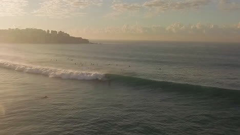 Goofy-Foot-Surfer-Dando-Un-Paseo-Largo-Y-Agradable-Con-Un-Barril-Al-Final-Poco-Después-Del-Amanecer-En-Bondi-Beach,-Sydney,-Australia