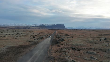 4K-drone-video-of-car-driving-away-on-a-dirt-road-in-Iceland