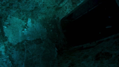 An-underwater-photographer-enters-a-plane-wreck-to-film-for-a-documentary