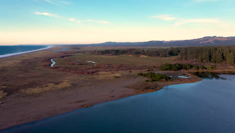 Drone-descending-over-shoreline-at-Floras-Lake-in-Langlois,-Oregon,-USA