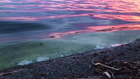 Nahaufnahme-Von-Wasserwellen-Mit-Schmutz,-Der-Am-Späten-Abend-Vom-Lerum-See-Espen-In-Schweden-Kommt,-Bei-Sonnenuntergang,-Der-Schöne-Farben-Erzeugt