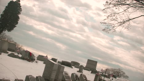 Snow-Covered-Cemetery-with-Cloudy-Sky-TILT-SLOW-MOTION