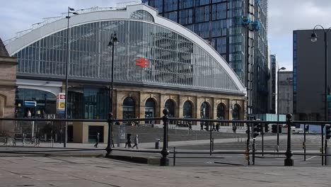 Large-arch-curve-Liverpool-Lime-St-Station-front-entrance-as-people---traffic-pass-by