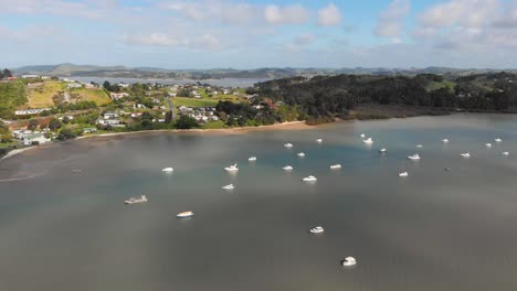 Flying-above-a-group-of-white-boats-near-the-peninsula-of-Pahi,-New-Zealand
