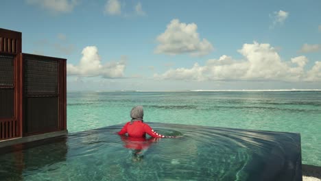 Woman-walks-to-the-edge-of-private-infinity-pool-at-luxury-resort-in-the-Maldives