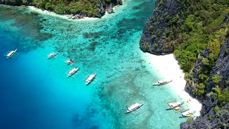 Aerial-of-turquoise-blue-sea-and-white-beach-of-Shimizu-island,-El-Nido,-Palawan,-Philippines