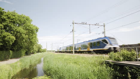 Un-Tren-Recorre-El-Paisaje-Holandés,-Cerca-De-Voorhout