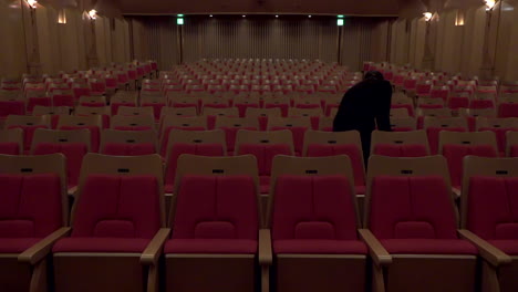 Ein-Mitarbeiter-Geht-Und-überprüft-Eine-Reihe-Von-Stühlen-In-Der-Oji-Halle,-Ginza,-Tokio,-Japan,-2018