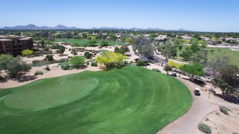 Aerial-golf-carts-race-along-the-edge-of-the-fairway-at-the-Westin-Kierland-Golf-Resort-stopping-at-the-outbuilding,-Scottsdale,-Arizona