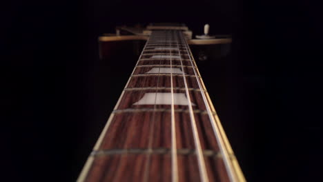 Langsame-Kamerafahrt-über-Das-Griffbrett-Einer-Gibson-Les-Paul-E-Gitarre,-Wobei-Sich-Die-Kamera-Auf-Den-Gitarrenkorpus-Bewegt