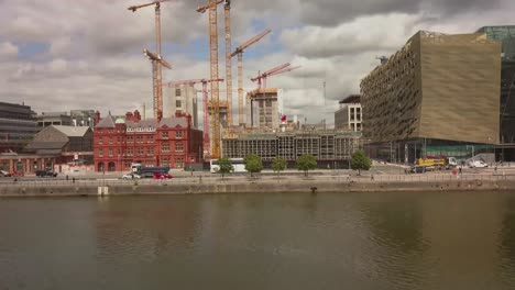 Panning-shot-of-construction-site-and-Anglo-Irish-bank-with-vehicles-passing-by-on-the-River-Liffey