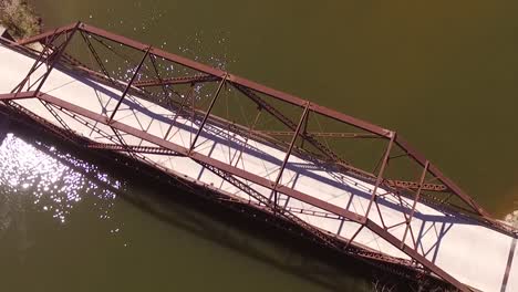 Aerial-flying-over-old-steel-bridge-on-river