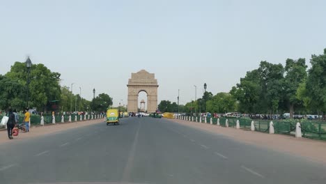 Ein-Blick-Auf-Die-Annäherung-An-Das-India-Gate-über-Straßen-Mit-Autos,-Fahrrädern,-Autos-Und-Menschen,-Die-In-Die-Entgegengesetzte-Richtung-Kommen