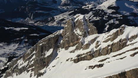 Vista-Aérea-De-Una-Bandeja-Lateral-A-La-Izquierda-De-Una-Cordillera-Cubierta-De-Nieve-En-Los-Alpes-Franceses
