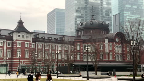 People-walking-and-girls-taking-a-selfie-at-old-building-of-tokyo-station,-Marunouchi-central-entrance-exit