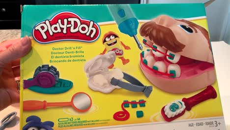 Hand-introducing-the-Classic-Play-Doh-Doctor-Fill-'n-Drill-toy-box