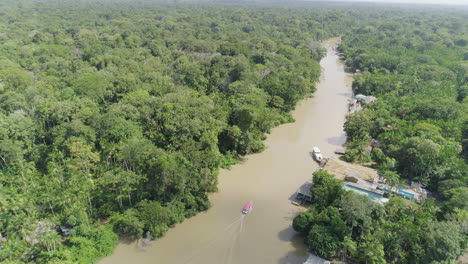 Aerial-shot-following-boat-on-amazonian-river-inside-jungle