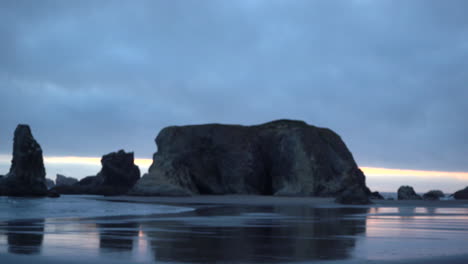 Moody-coast-landscape-with-sea-stacks-in-Bandon-oregon,-Pacific-Northwest,-beautiful-reflections-in-sand,-zoom-in