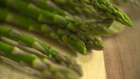 A-bunch-of-fresh,-green-asparagus-sitting-on-a-wooden-cutting-board